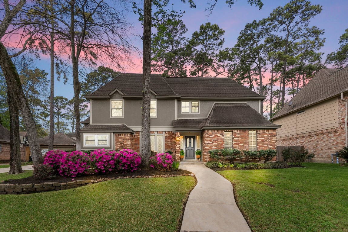 a front view of a house with a garden and trees