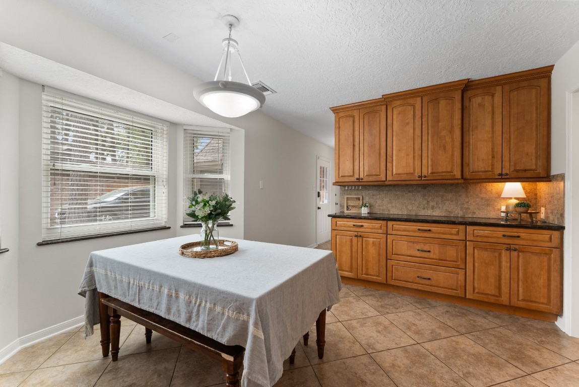16927 Windypine Drive Spring, TX 77379 - Photo 13 of 46 a kitchen with a table chairs stove and cabinets