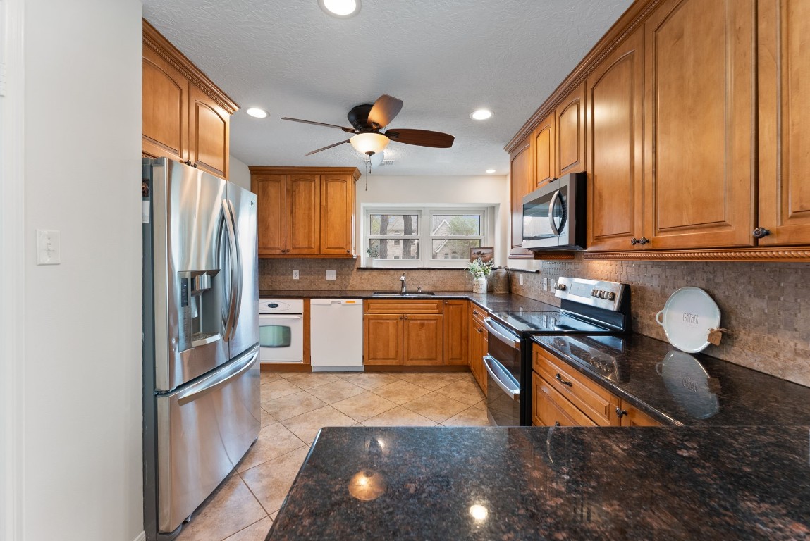16927 Windypine Drive Spring, TX 77379 - Photo 14 of 46 a kitchen with stainless steel appliances granite countertop a stove a sink and a refrigerator
