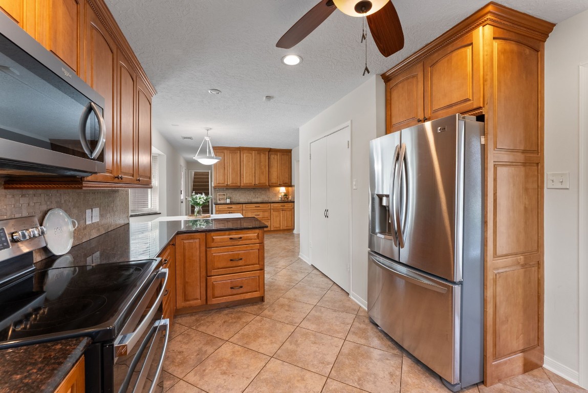 16927 Windypine Drive Spring, TX 77379 - Photo 15 of 46 a kitchen with granite countertop a refrigerator stove and sink