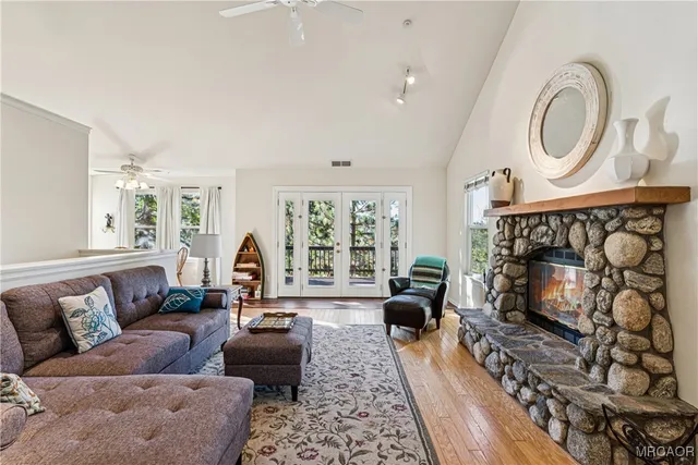a living room with furniture a fireplace and a floor to ceiling window
