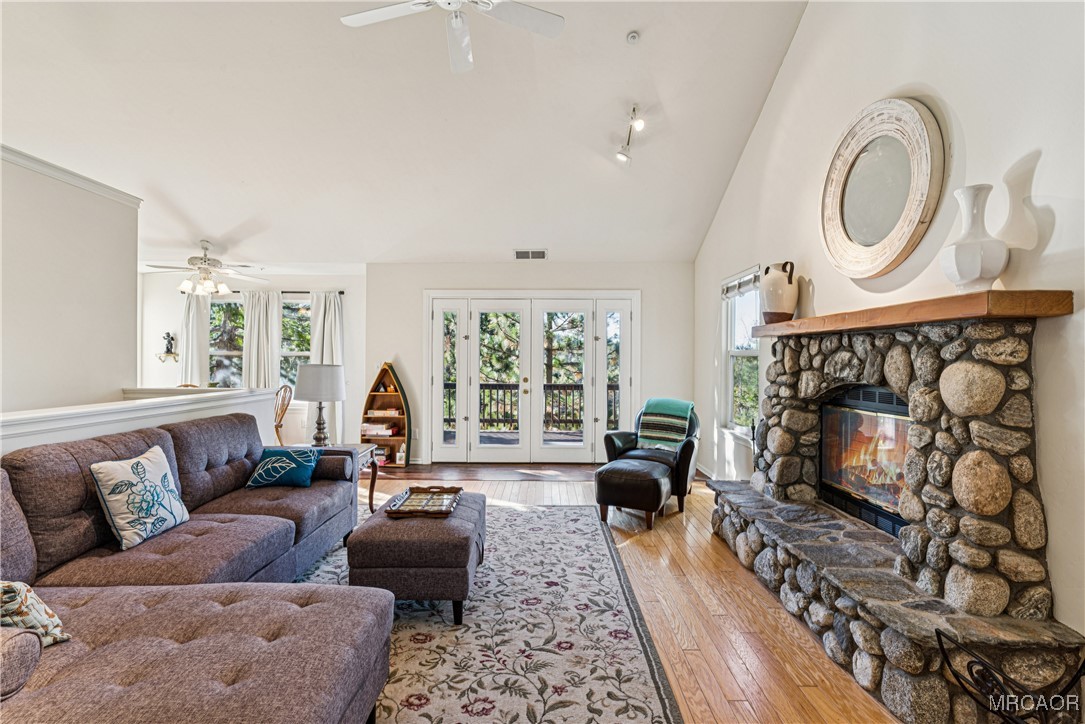 a living room with furniture a fireplace and a floor to ceiling window