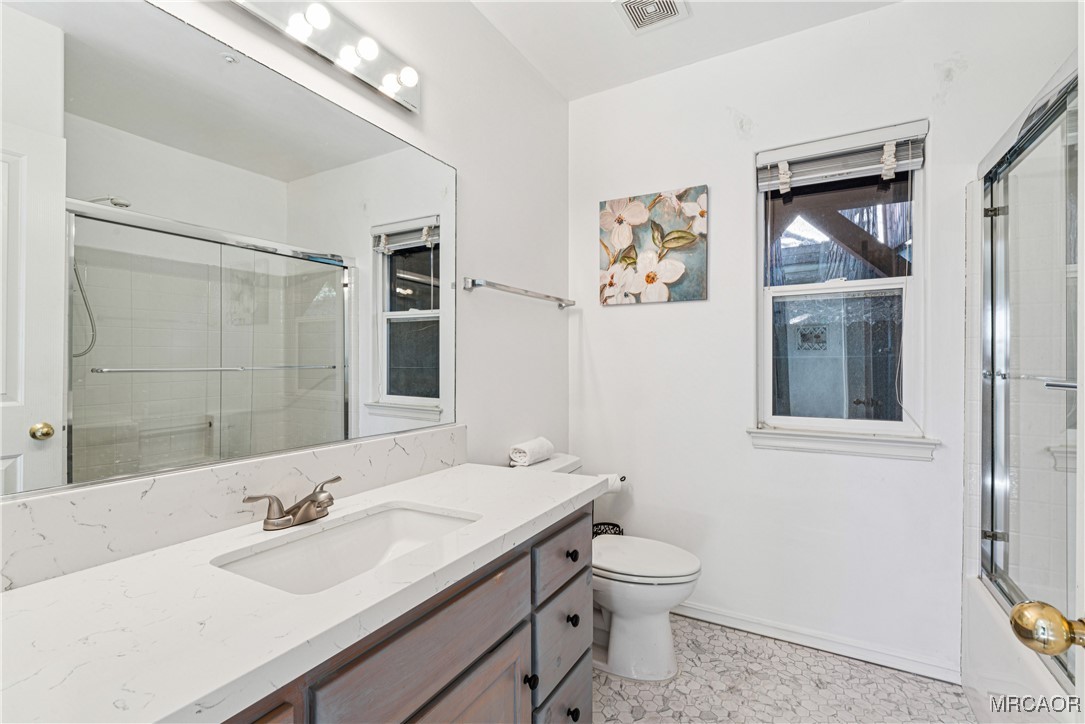 305 Summit Road Lake Arrowhead, CA 92352 - Photo 29 of 47 a bathroom with a granite countertop sink a toilet and a mirror