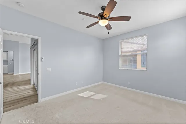 a view of an empty room with a ceiling fan