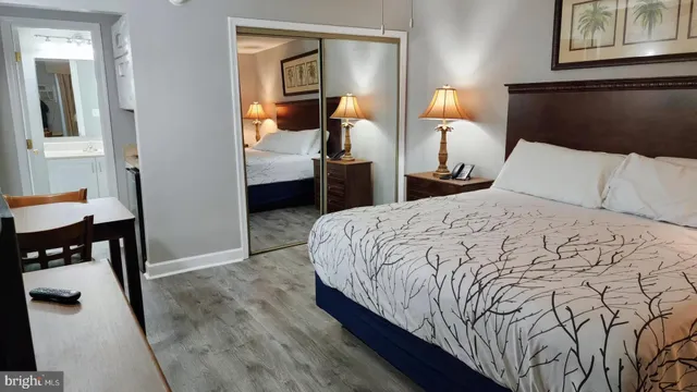 a bedroom with a bed and a lamp on dresser