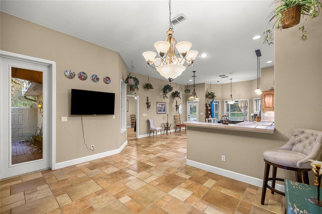4280 Southeast 26th Terrace Road Ocala, FL 34480 - Photo 16 of 70 a view of a kitchen with kitchen island a sink and a flat screen tv