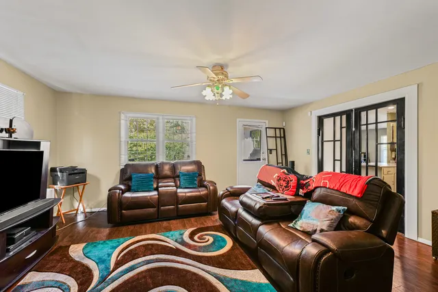a living room with furniture ceiling fan and a window