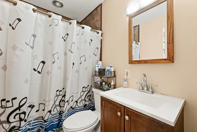 a bathroom with a sink a toilet and shower curtain