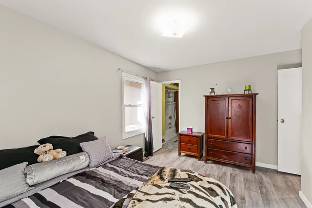 a bedroom with a bed and wooden floor