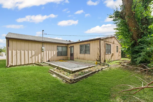 a backyard of a house with table and chairs