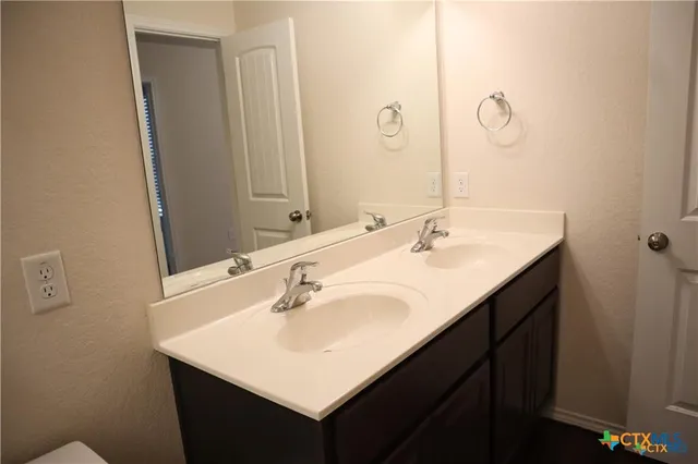 a bathroom with a sink vanity and a mirror