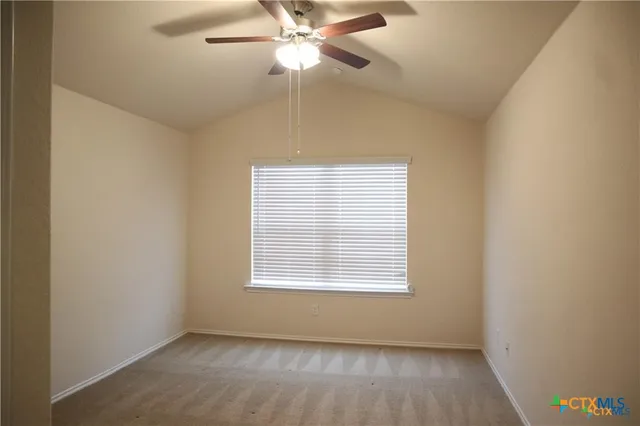 an empty room with a window and a fan