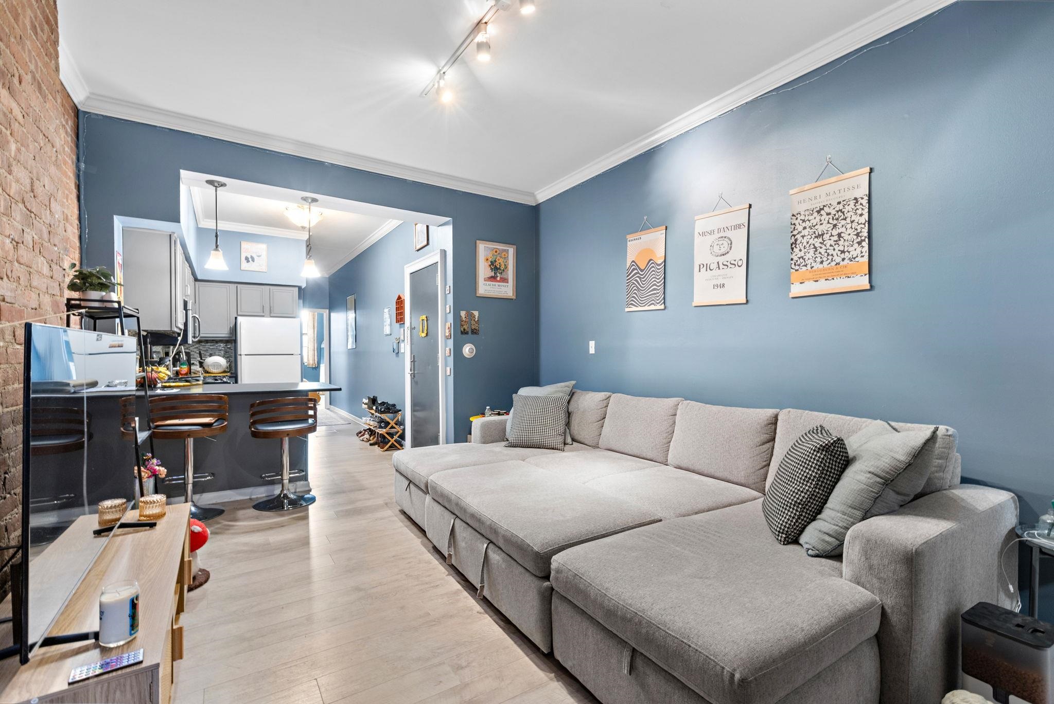 263 1st Street, Unit 2R Hoboken, NJ 07030 - Photo 2 of 13 a living room with furniture and kitchen view