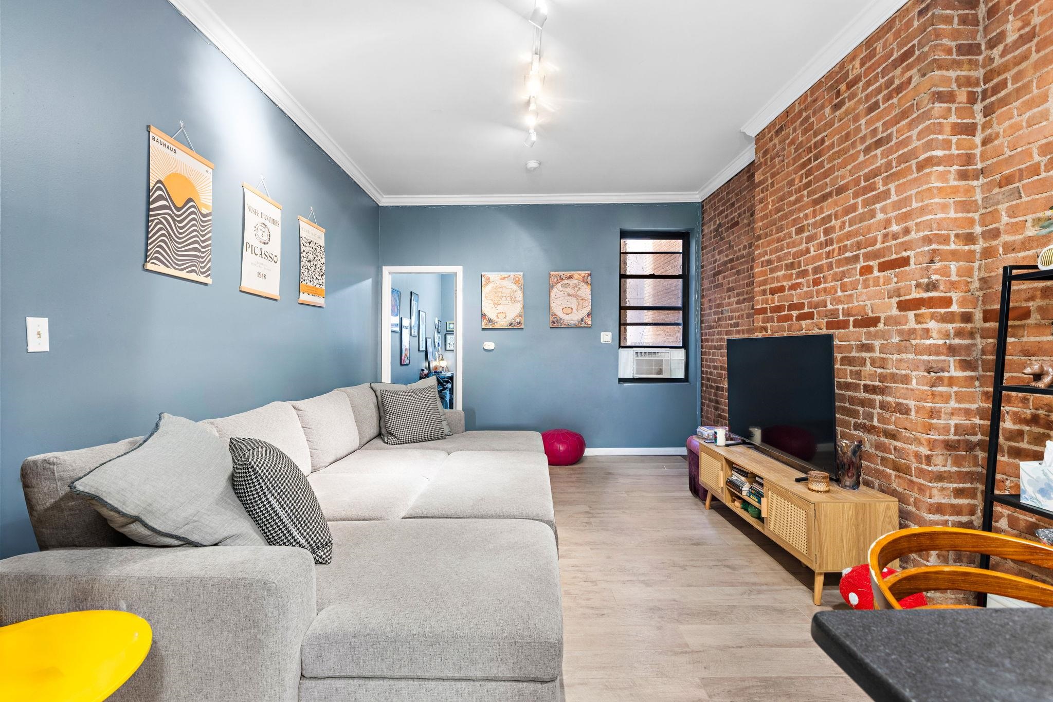 263 1st Street, Unit 2R Hoboken, NJ 07030 - Photo 3 of 13 a living room with furniture and a flat screen tv