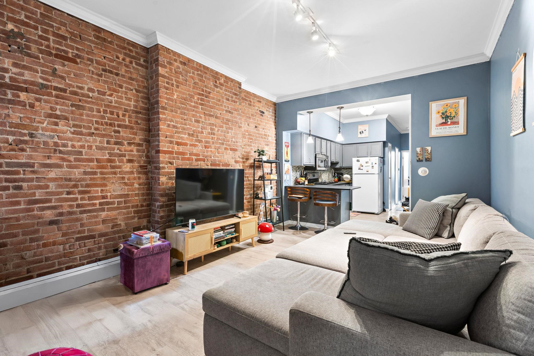 263 1st Street, Unit 2R Hoboken, NJ 07030 - Photo 4 of 13 a living room with furniture and a flat screen tv