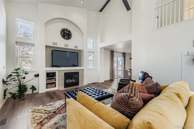 a living room with furniture a flat screen tv and a fireplace