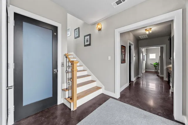a view of a hallway with wooden floor and stairs