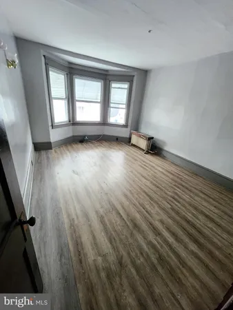 a view of a room with wooden floors and window
