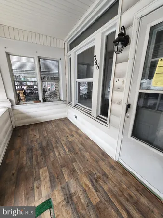 a view of a hallway with wooden floor and furniture
