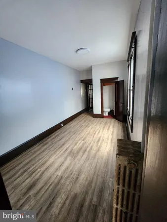 a view of a livingroom with wooden floor and a window