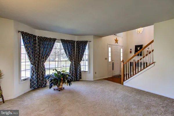 an entryway of a house with wooden floor and windows
