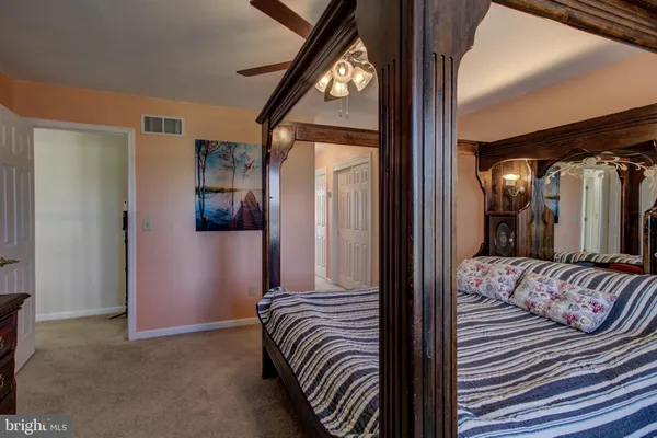 a view of a hallway with wooden floor and a bathroom