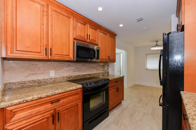 a kitchen with stainless steel appliances granite countertop a stove a refrigerator and a microwave