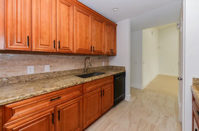 a kitchen with stainless steel appliances granite countertop a sink window and cabinets