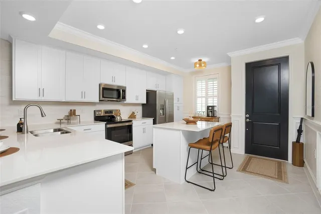 a kitchen with stainless steel appliances a refrigerator stove microwave and sink