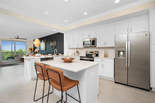 a kitchen with stainless steel appliances a table chairs refrigerator and a sink