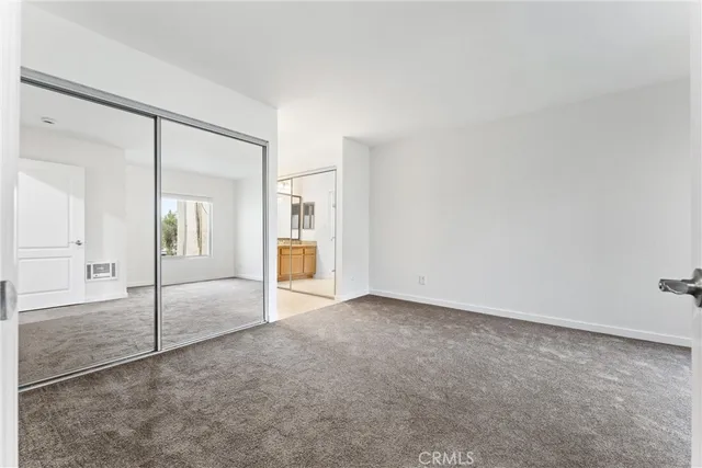 an empty room with mirror and a sink