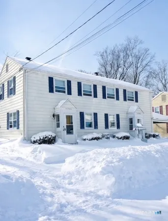 a front view of a house with a yard covered in snow