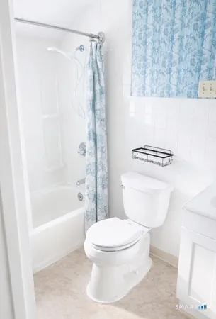 a white toilet sitting next to a bath tub and a shower