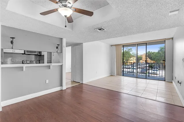 a view of a kitchen with furniture a ceiling fan and window