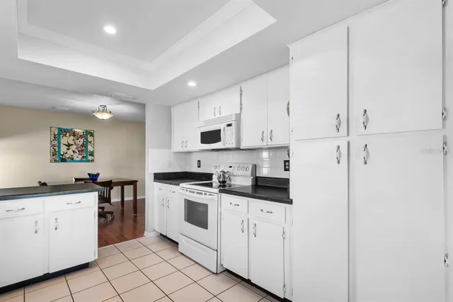 a kitchen with white cabinets and white appliances