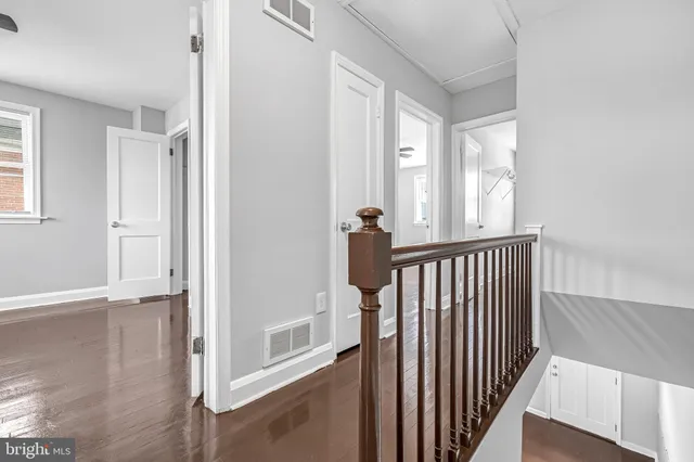 a view of a hallway with wooden floor and staircase