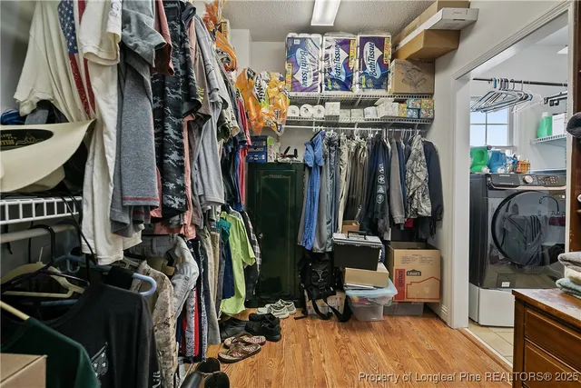a view of walk in closet with clothes and shoes
