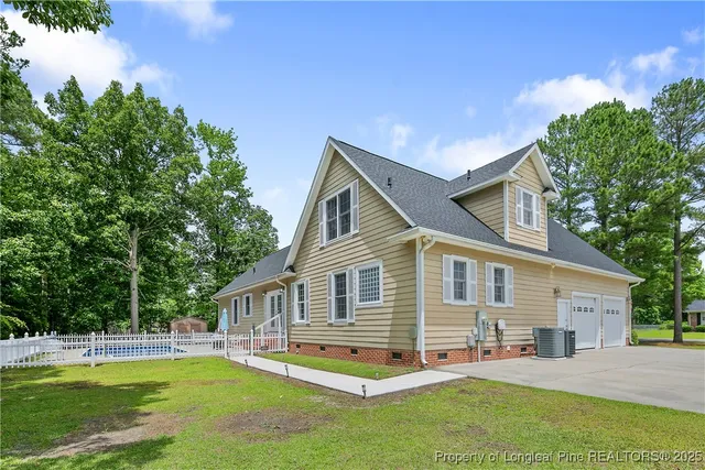 a view of a brick house next to a yard with large trees