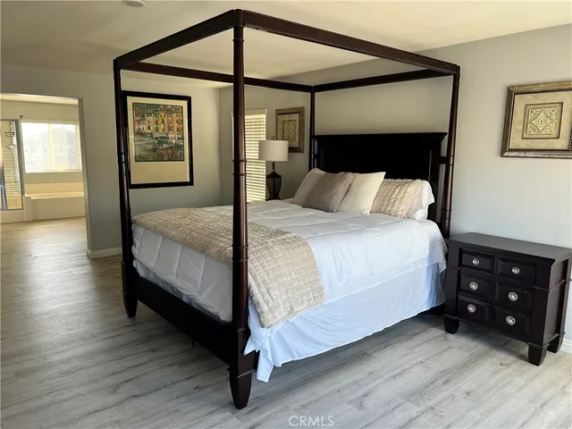 a bedroom with a bed a mirror and a dresser