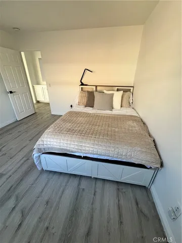 a bedroom with a bed and wooden floor