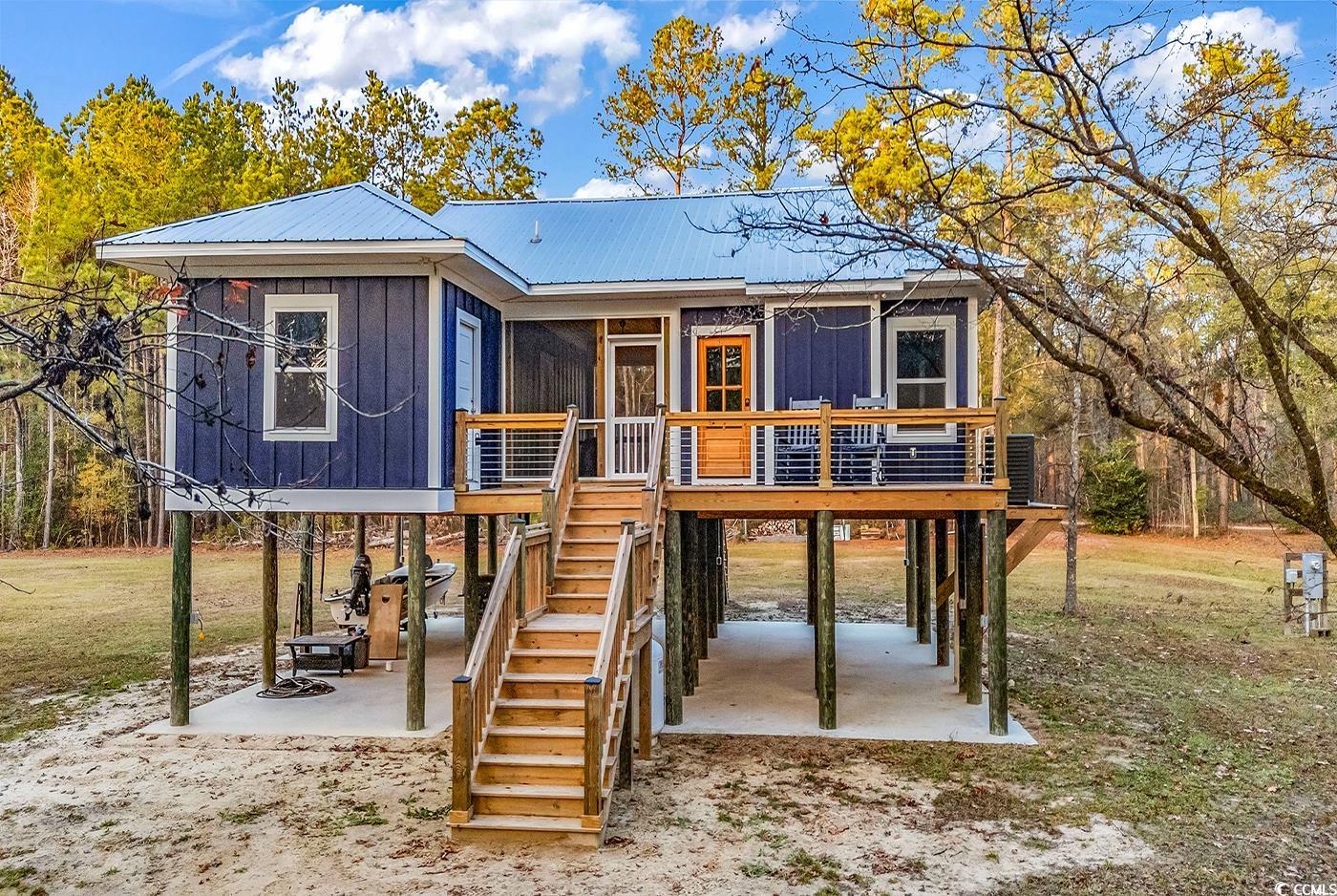 32 Old Place Kingstree, SC 29556 - Photo 2 of 40 View of front of property featuring stairs, a deck, board and batten siding, a metal roof, and a carport