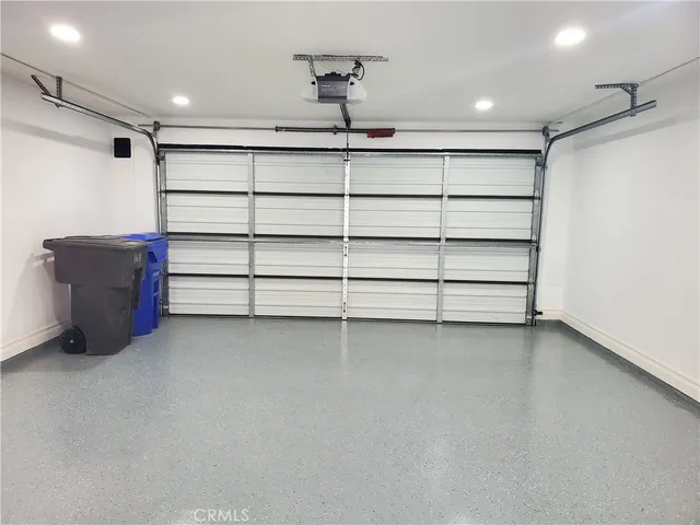 a view of an empty room with shelves and a ceiling fan