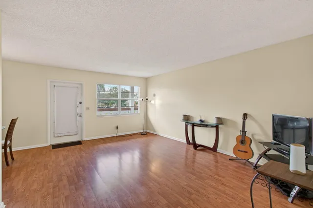 a bedroom with a bed and a dresser with wooden floor