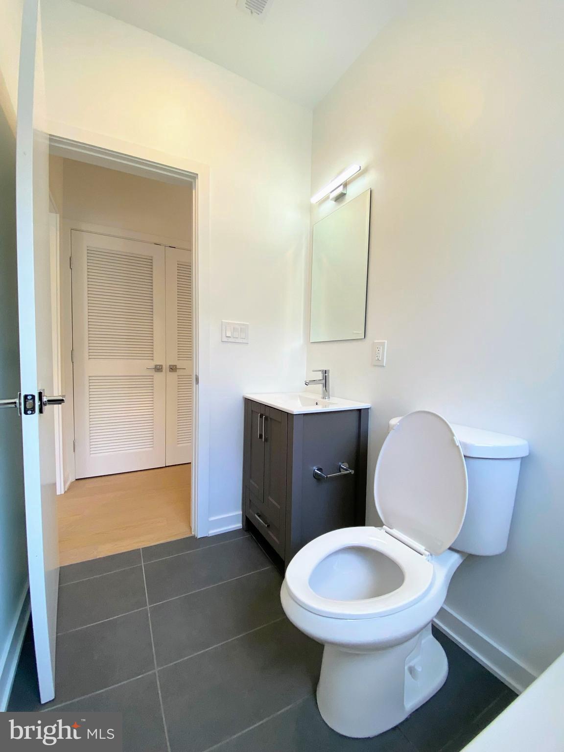 3435 Brown Street Northwest, Unit 1 Washington, DC 20010 - Photo 10 of 13 a bathroom with a toilet a sink and mirror