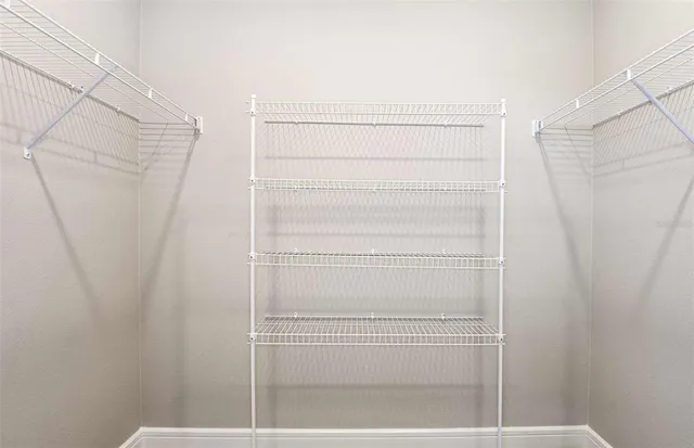a view of walk in closet with empty racks
