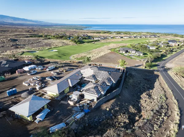 an aerial view of a building with garden space and ocean view
