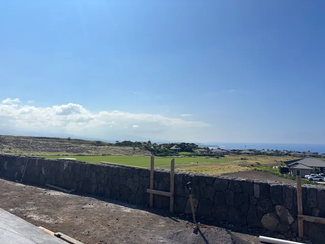 a view of a swimming pool with lawn chairs under an umbrella
