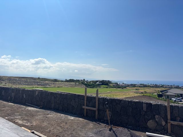 a view of a swimming pool with lawn chairs under an umbrella