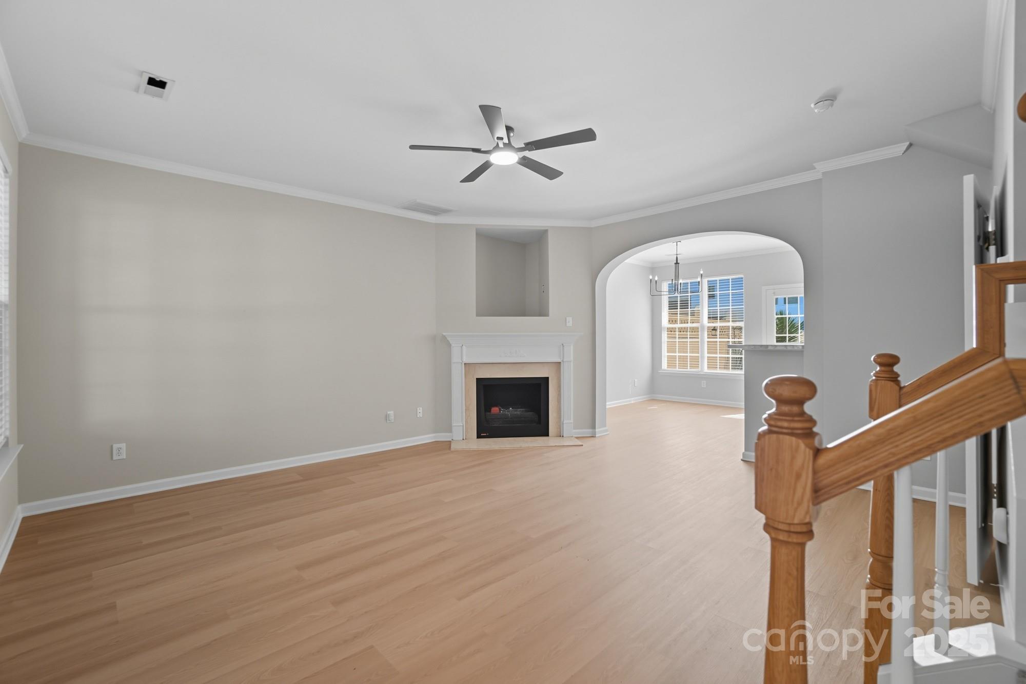 507 Poseidon Way Fort Mill, SC 29708 - Photo 2 of 19 a view of a livingroom with a fireplace a chandelier fan and wooden floor