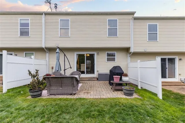 a front view of a house with a garden and chairs